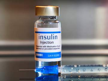 bottle of insulin and a hypodermic needle