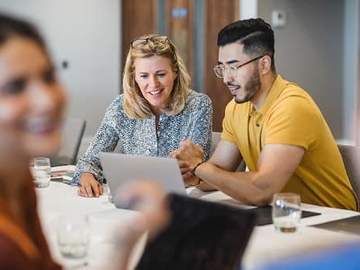 coworkers looking at laptop