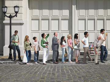line of people in a street standing in a queue
