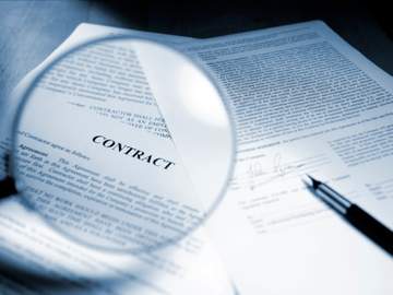 magnifying glass above paper contract