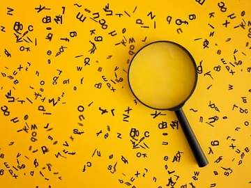 magnifying glass on yellow background surrounded by letters