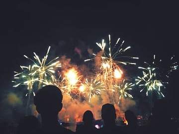 silhouettes of people watching fireworks