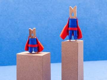 two clothes pins dressed in capes up on first and second place podiums