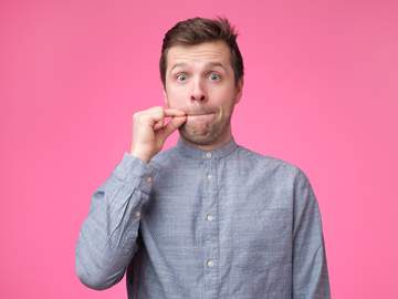 young man zipping his lips in a sign of silence