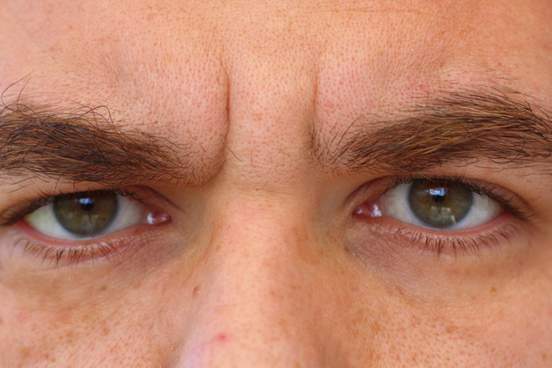 a close-up of a man showing only his eyes and his bushy eyebrows