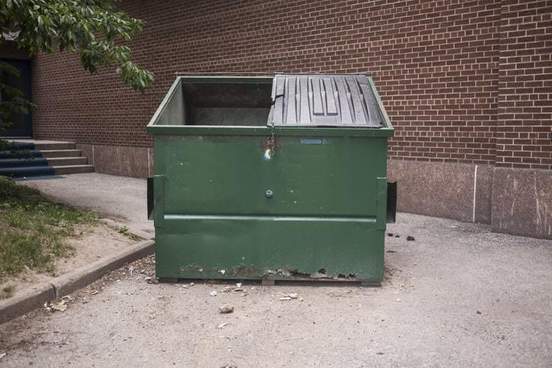 a dumpster sitting on the side of a building