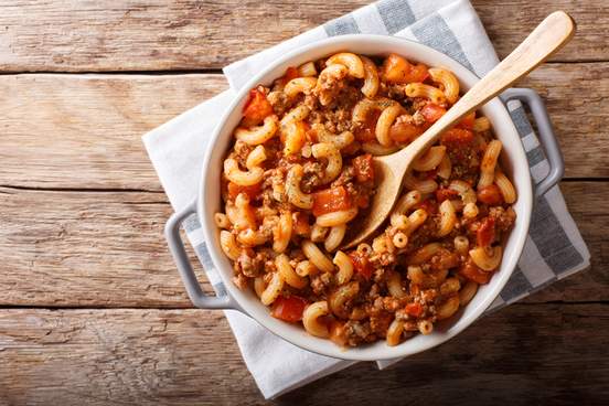 american chop suey american goulash with elbow pasta beef and tomatoes close-up in a saucepan 