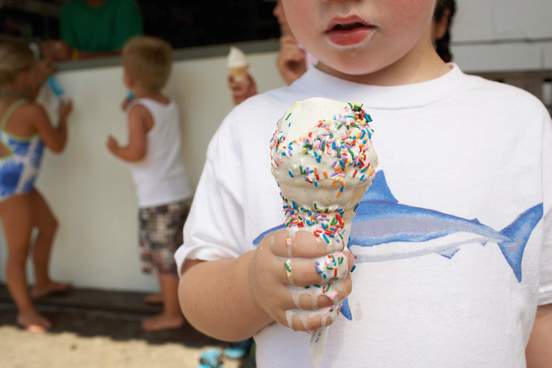 boy 3-5 eating ice cream close-up other children in background