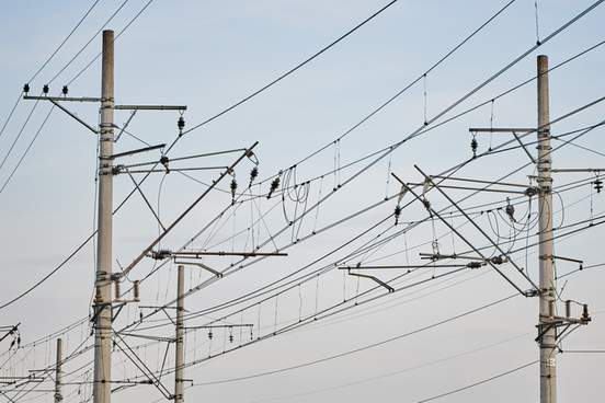 catenary railway traction overhead line electricity pylons on railway track against blue sky high voltage transmission supplying electricity for trains with a pylon pillar in 