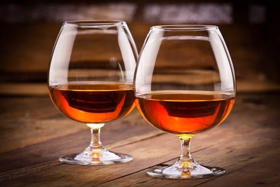 cognac snifters on rustic wood table 