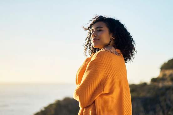 confident and hopeful young woman stands on the beach