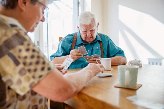 elderly couple playing cards together