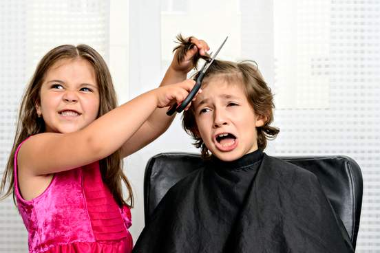 evil looking girl cuts her brothers hair