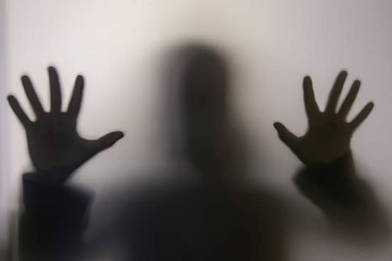 ghostly figure behind clouded glass