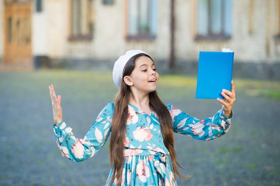 girl reading poetry out loud from a book