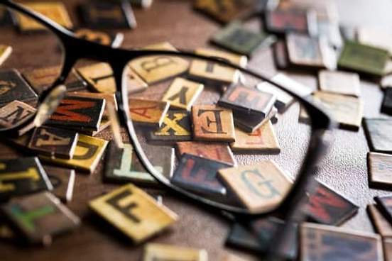 glasses on top of pile of letter blocks