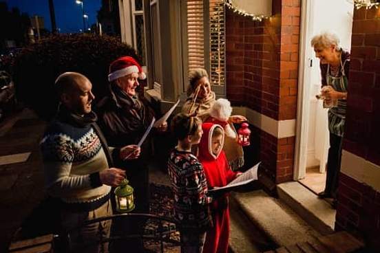 group of carolers singing at doorstep