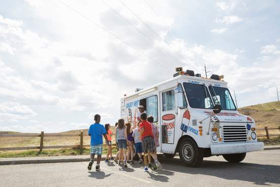 group of children buying ice cream from a truck
