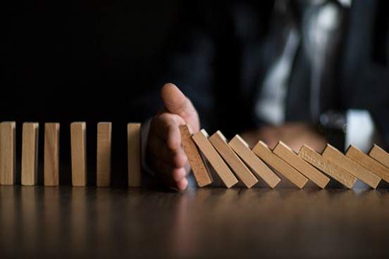 hand stopping dominoes