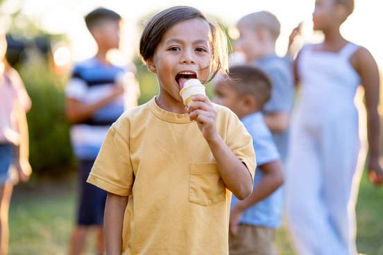 happy child eating soft serve ice cream cone