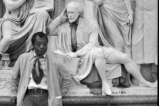 james baldwin standing in front of shakespeare statue