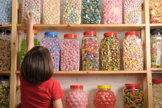 kid in a candy store reaching for jar of candy