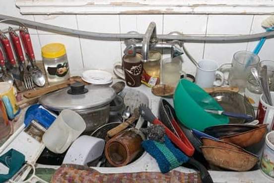 kitchen sink overflowing with dirty dishes