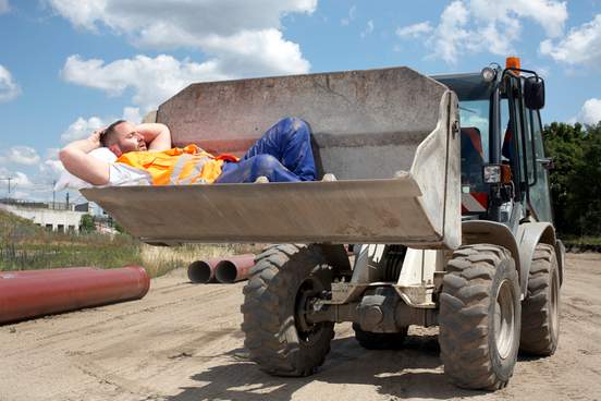 man asleep in bucket of earth mover