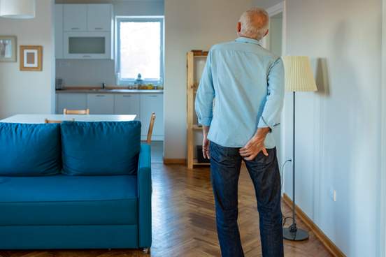 man clutching his buttocks in pain