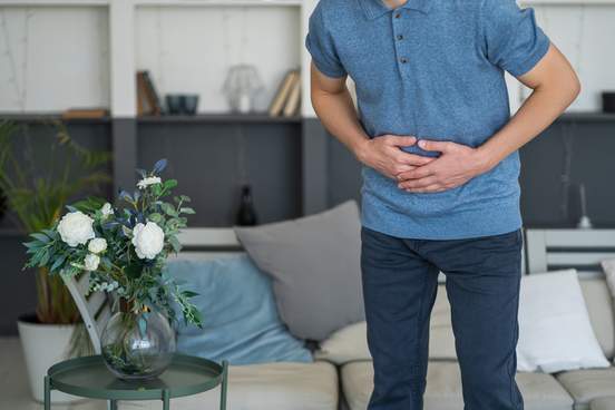 man grabbing his stomach in pain