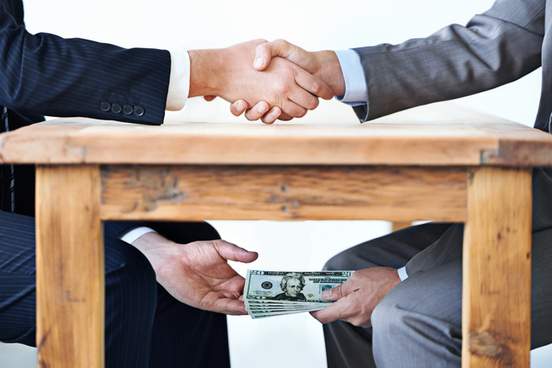man handing money under table to another man
