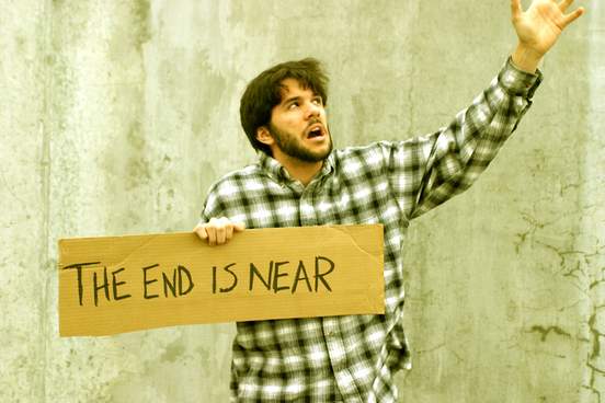 man holding sign reading the end is near
