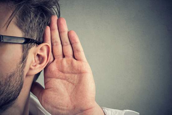 man holds his hand near ear and listens carefully 