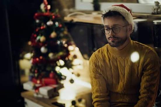 man looking unhappy in santa hat