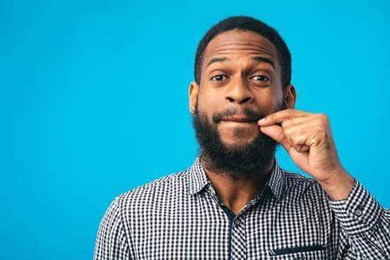 man making zip it gesture