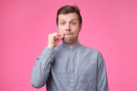 man making zipped lips gesture