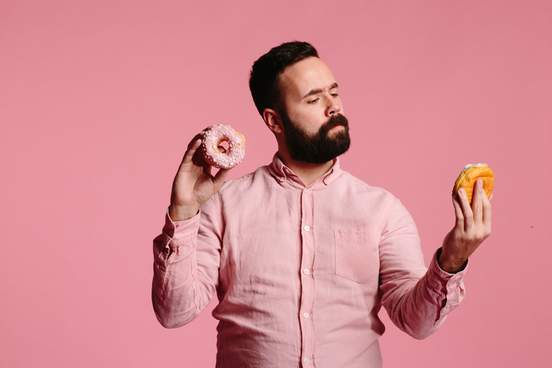 man undecided about which donut to eat