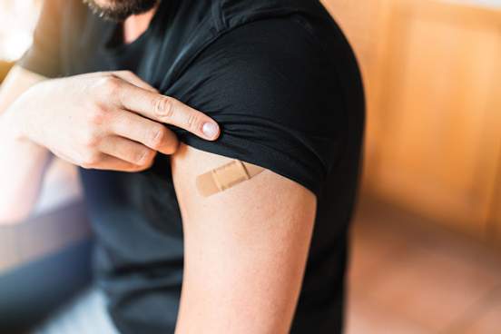 man with band aid on arm