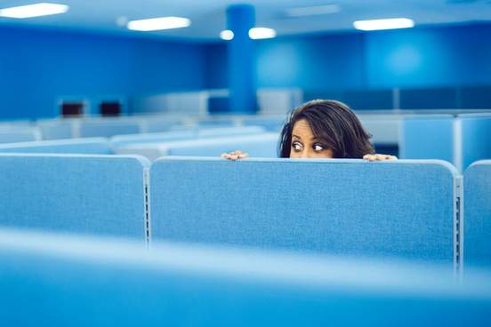 office worker peeking over a partition