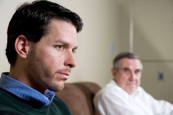 pensive man sitting down with his father looking at him