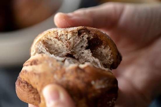 person breaking bread roll