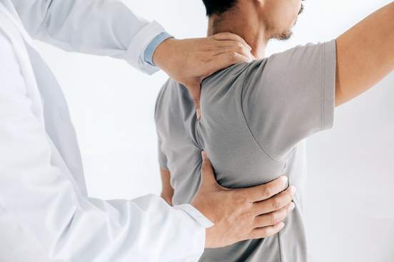 physiotherapist doing healing treatment on mans back