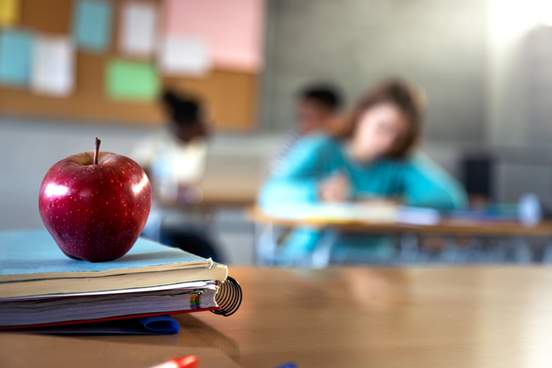 polished apple sits on teachers desk