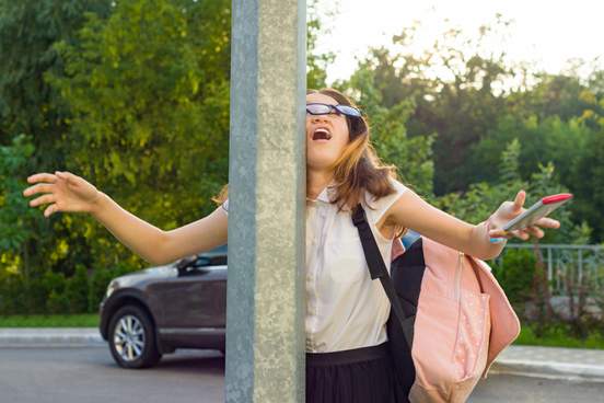portrait of young inattentive girl distracted by mobile phone girl crashed into street post dropped phone