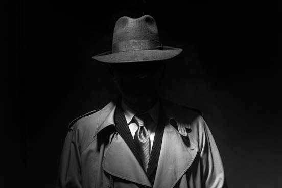 shadowy person in trenchcoat and hat