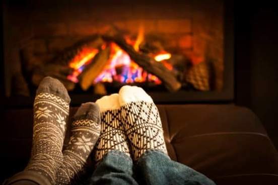 two people warming feet by fire