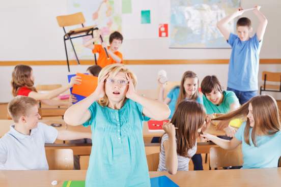 uncontrollable pupils in classroom acting out frustrated teacher tearing a hair out