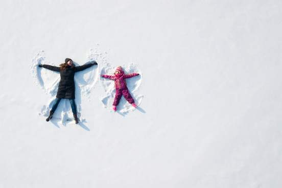 woman and child making snow angels