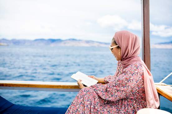 woman reading a book on a boat