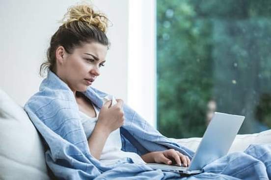 woman reading while sick in bed